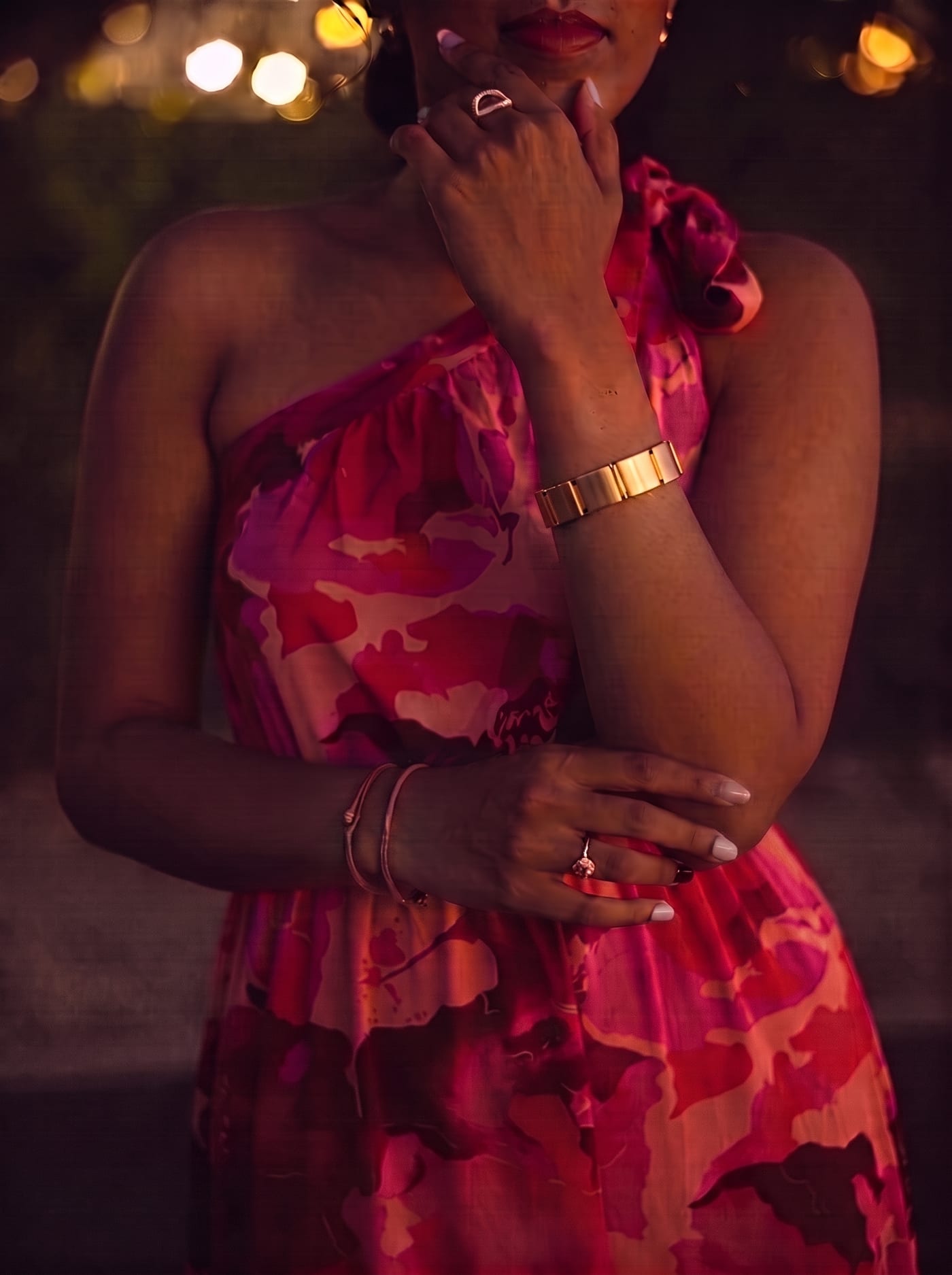 A woman in evening light with the Vitul bracelet on her wrist, one hand resting at her chin